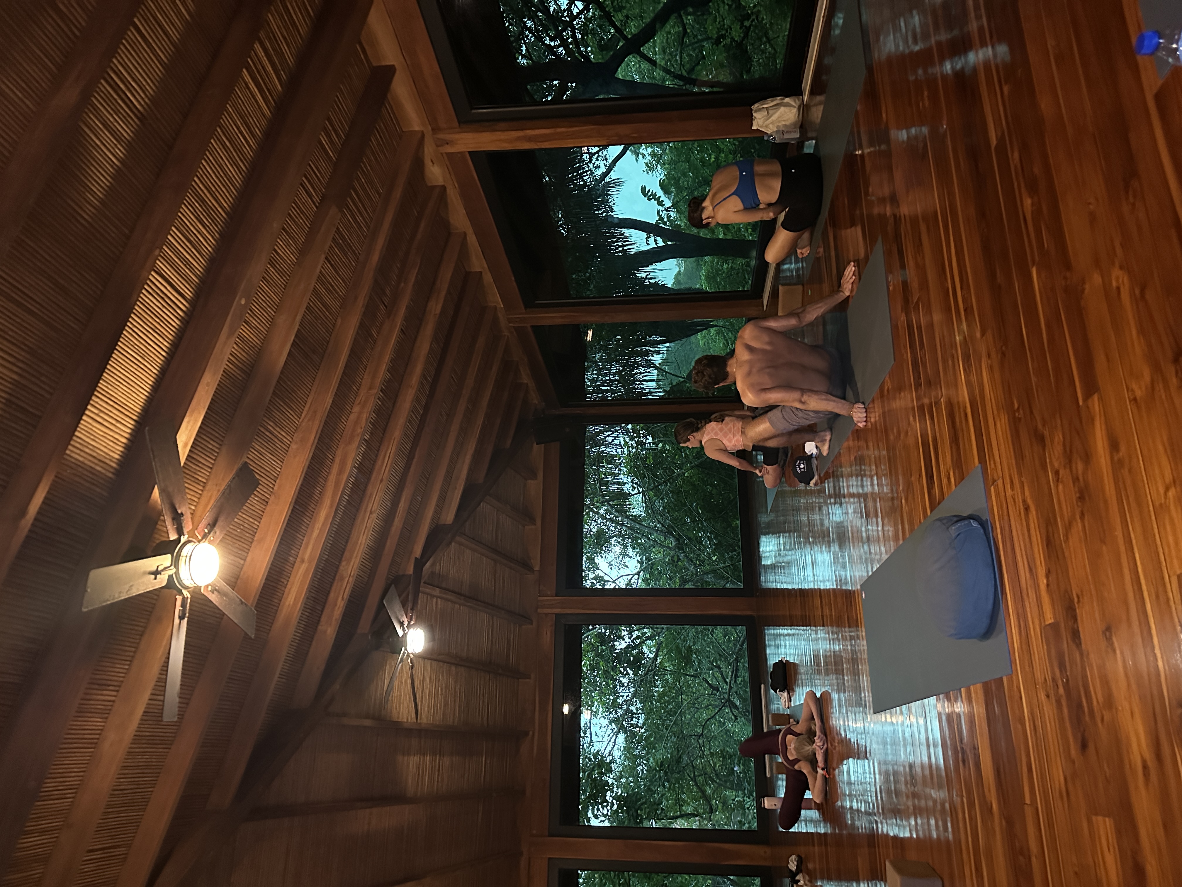 Open wooden pavilion surrounded by greenery